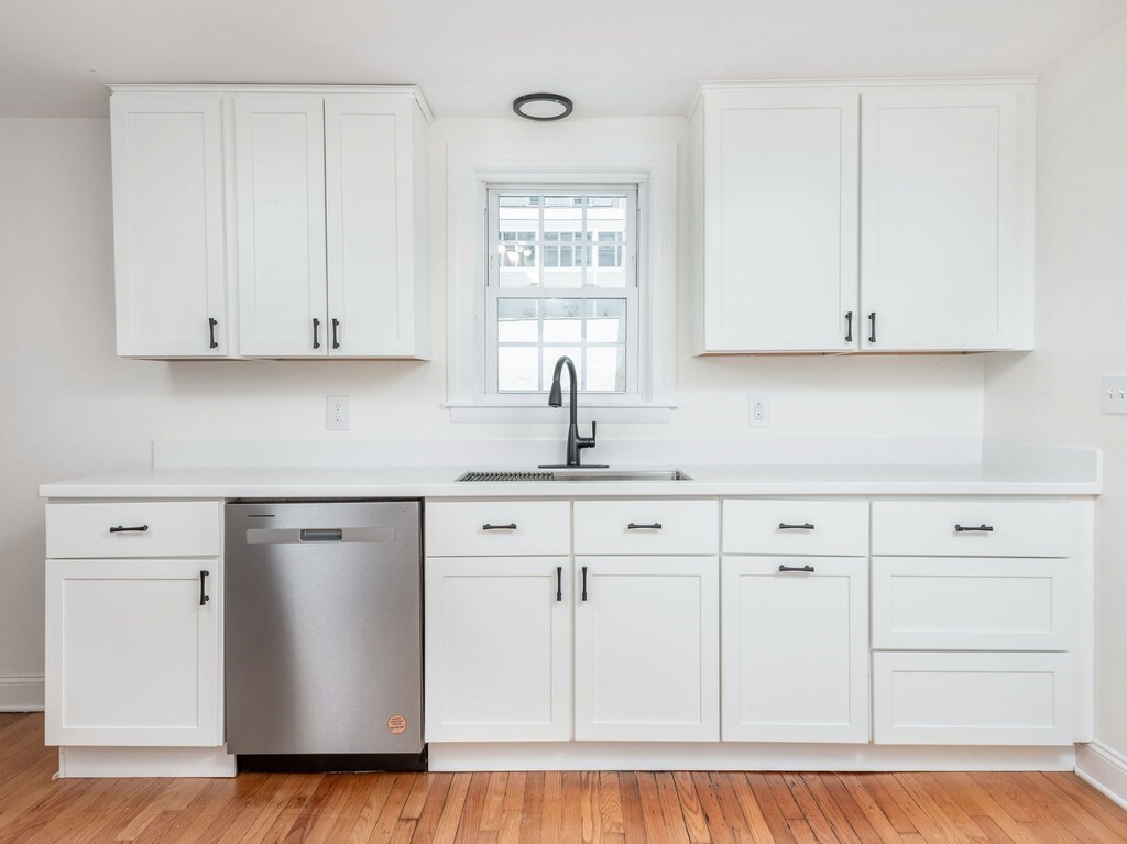 63 Upland Street Worcester, MA 01607 - Photo 7 of 36 a kitchen with granite countertop white cabinets and sink