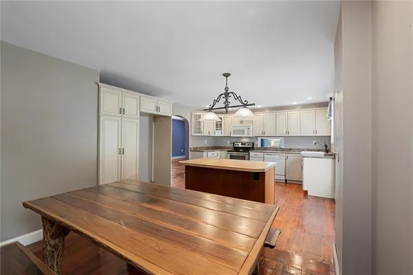 a kitchen with kitchen island stainless steel appliances a sink stove and refrigerator