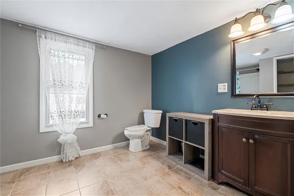 a spacious bathroom with a double vanity sink a toilet and a window