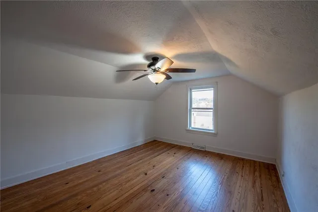 a view of wooden floor and a chandelier fan in a room
