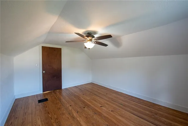 a view of a room with wooden floor and ceiling fan