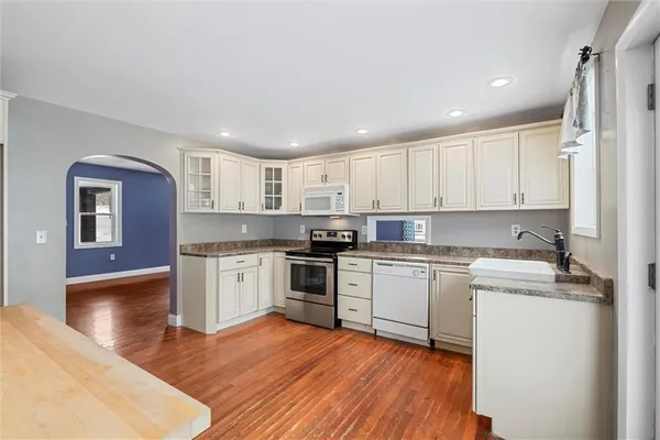 a kitchen with a refrigerator stove top oven and sink