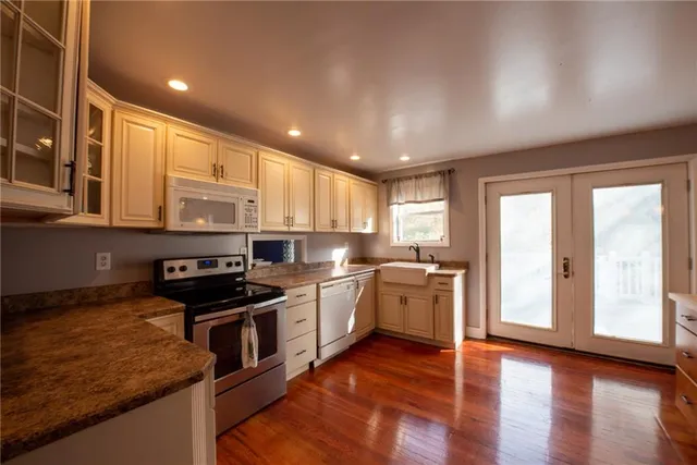 a kitchen with stainless steel appliances granite countertop a stove a sink and a refrigerator
