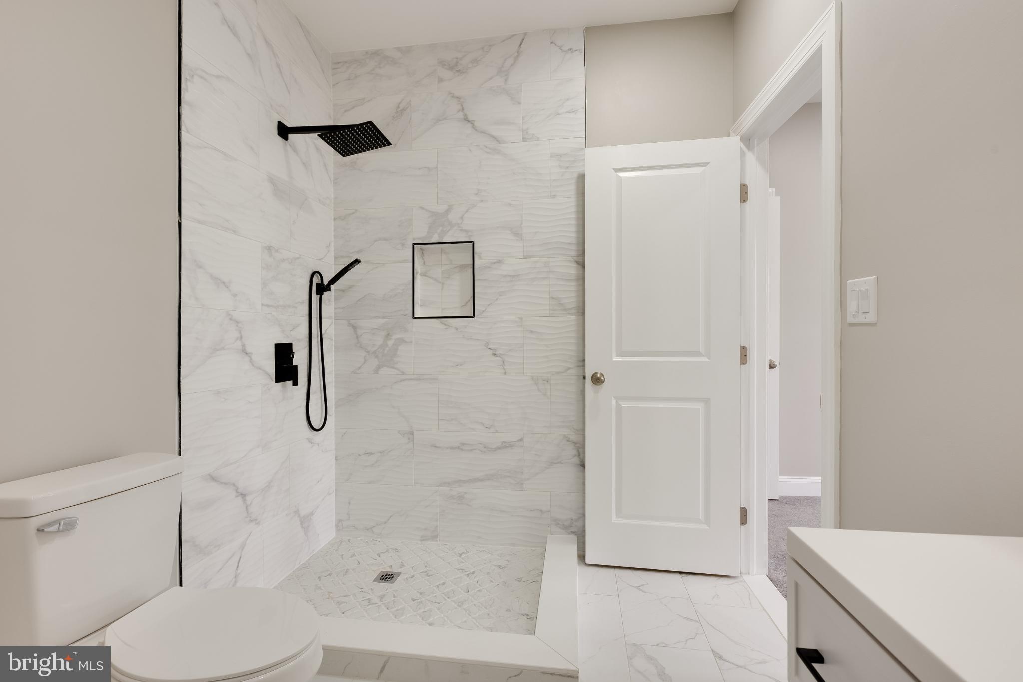 5239 Arch Street Philadelphia, PA 19139 - Photo 16 of 36 Sleek marble shower in modern bathroom.