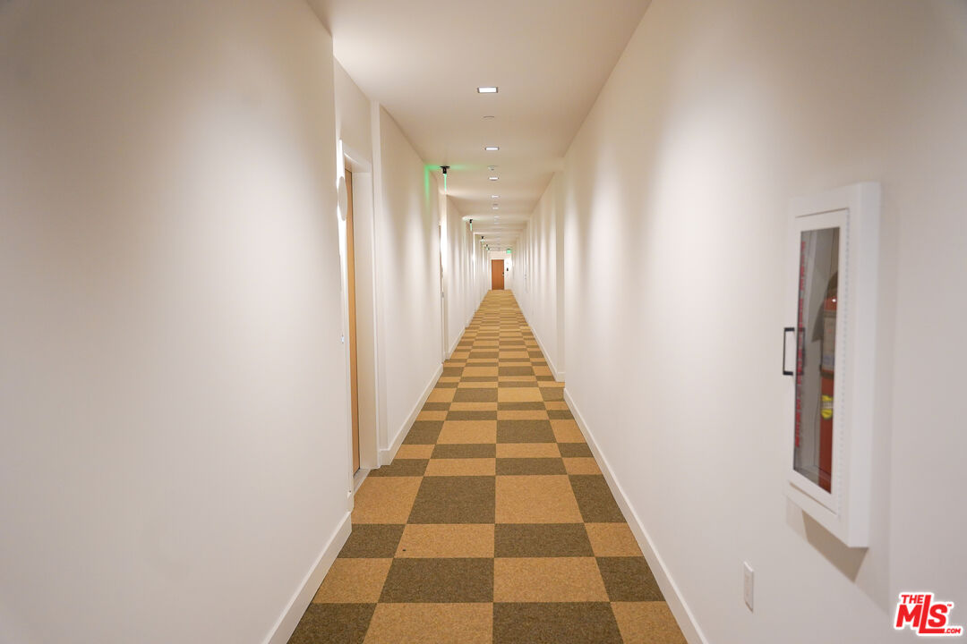 200 Mesnager Street, Unit 618 Los Angeles, CA 90012 - Photo 13 of 24 a view of a hallway with white walls and a black white checkered floor