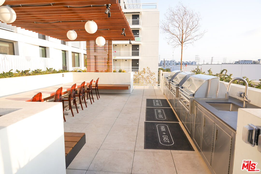 200 Mesnager Street, Unit 618 Los Angeles, CA 90012 - Photo 22 of 24 a view of a patio with dining table and chairs with wooden floor