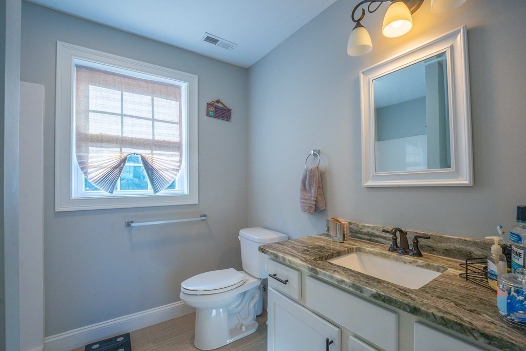 176 Oakham Road Barre, MA 01005 - Photo 25 of 36 a bathroom with a granite countertop toilet a sink and a window