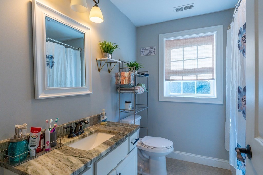 176 Oakham Road Barre, MA 01005 - Photo 26 of 36 a bathroom with a granite countertop sink a toilet and a mirror