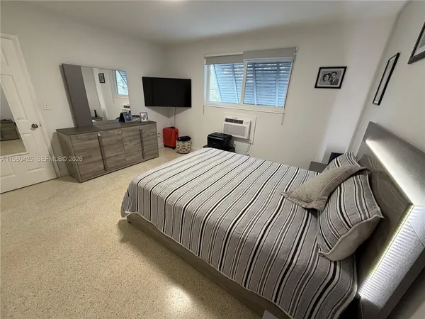 a bedroom with a bed and flat screen tv