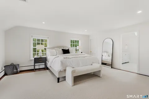 a bed sitting in a spacious bedroom next to a window