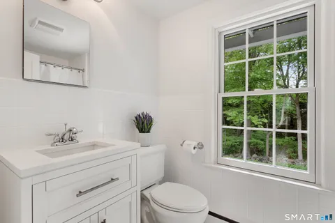 a bathroom with a sink a toilet and a mirror
