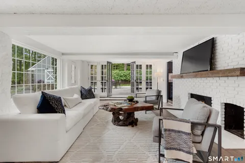 a living room with furniture large window and a flat screen tv