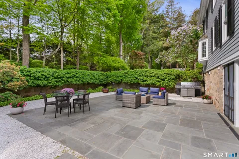 a view of a chairs and table in the back yard of the house