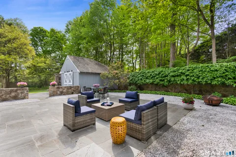 a view of a patio with couches and a table and chairs with plants and trees