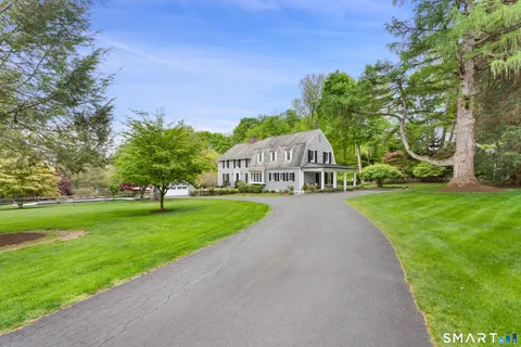 a view of a house with garden and trees