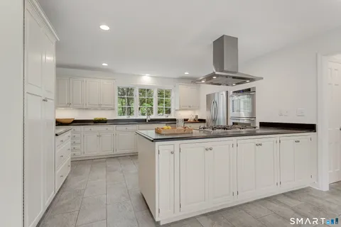 a kitchen with white cabinets and sink