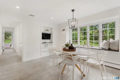a living room with furniture a flat screen tv and a large window