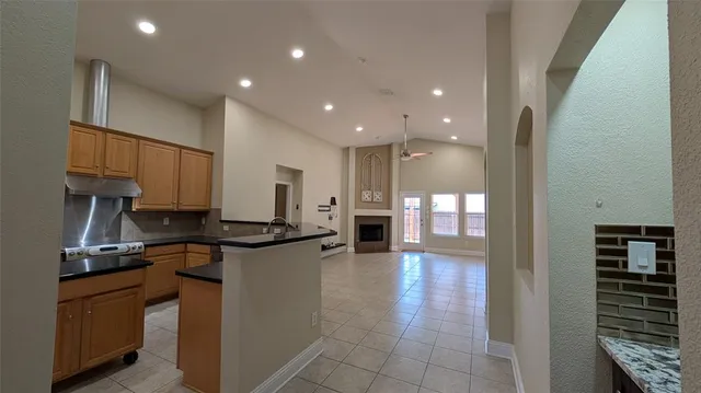 a kitchen with stainless steel appliances granite countertop a refrigerator a stove and a sink