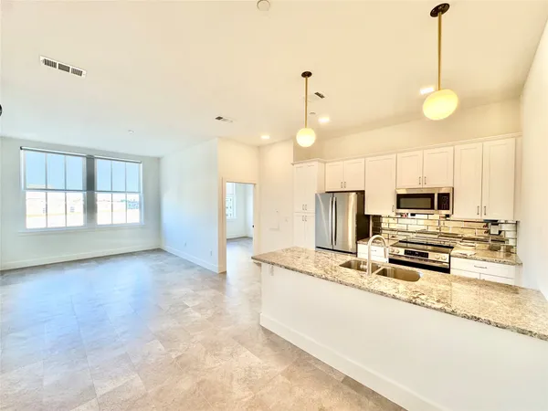 a kitchen with stainless steel appliances a refrigerator sink and stove