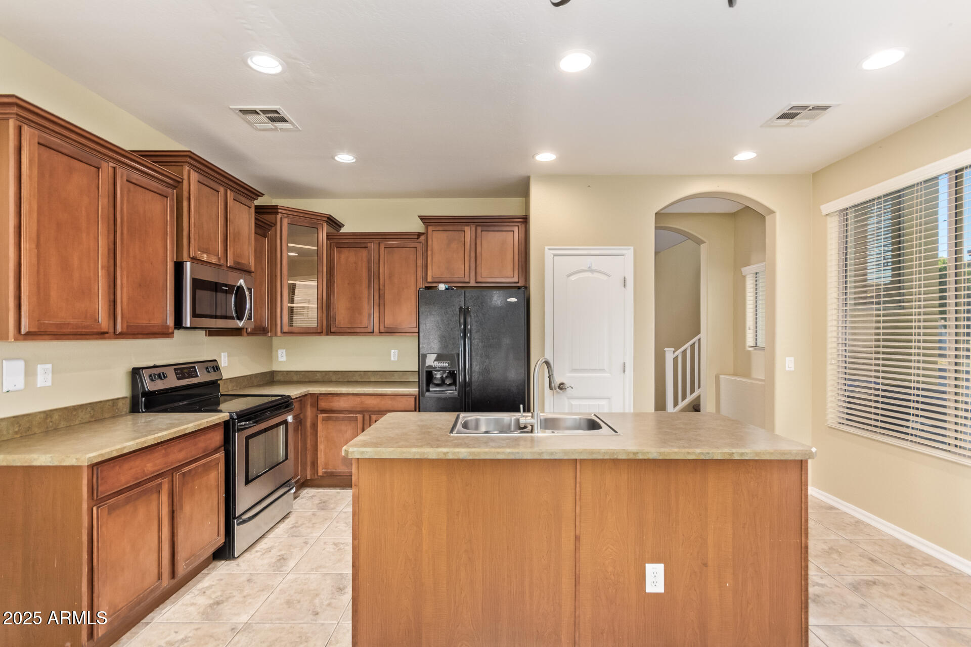 15170 North 145th Lane Surprise, AZ 85379 - Photo 14 of 40 a kitchen with stainless steel appliances granite countertop a sink stove and refrigerator