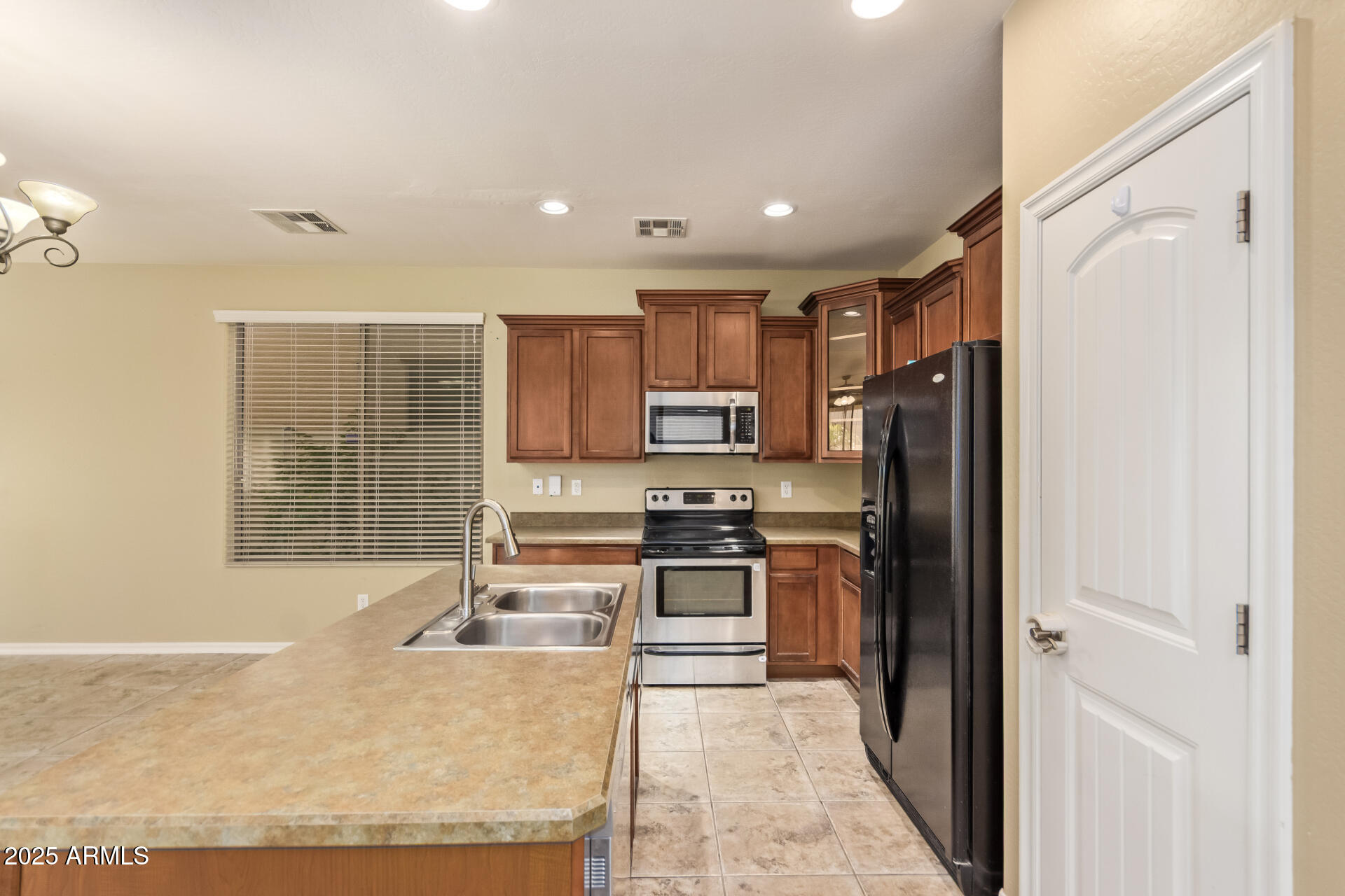 15170 North 145th Lane Surprise, AZ 85379 - Photo 15 of 40 a kitchen with stainless steel appliances granite countertop a refrigerator and a stove top oven