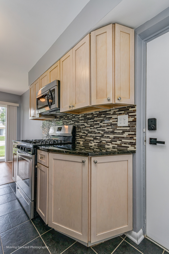 1234 Elder Court, Unit 1234 Wheeling, IL 60090 - Photo 12 of 24 a kitchen with stainless steel appliances granite countertop a stove a sink and a microwave