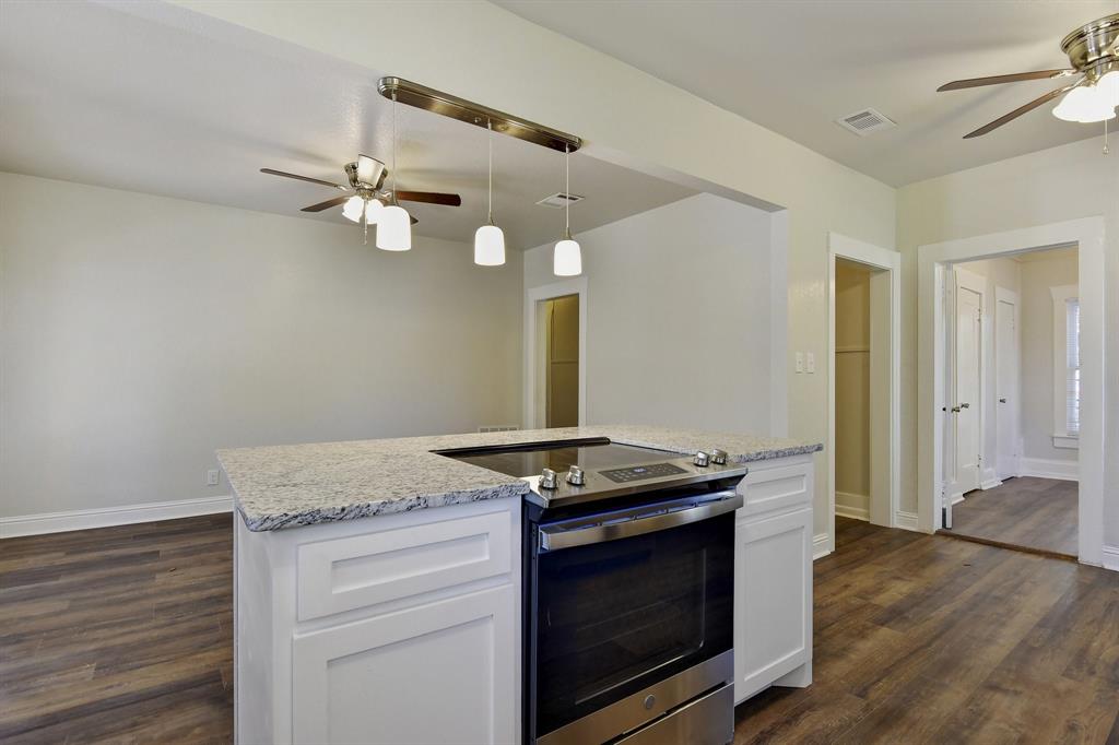 1115 South Rusk Avenue Denison, TX 75020 - Photo 9 of 21 a kitchen with a stove cabinets and wooden floor