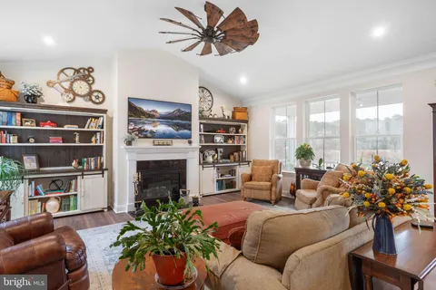a living room with furniture a fireplace and a chandelier