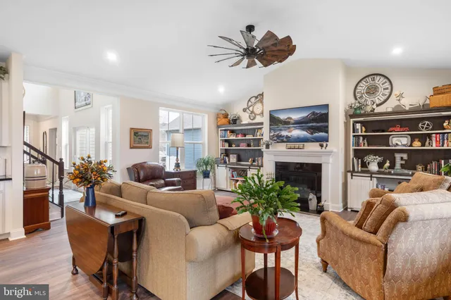 a living room with furniture kitchen view and a large window