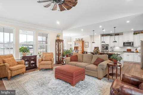 a kitchen with stainless steel appliances kitchen island granite countertop a table chairs and a sink