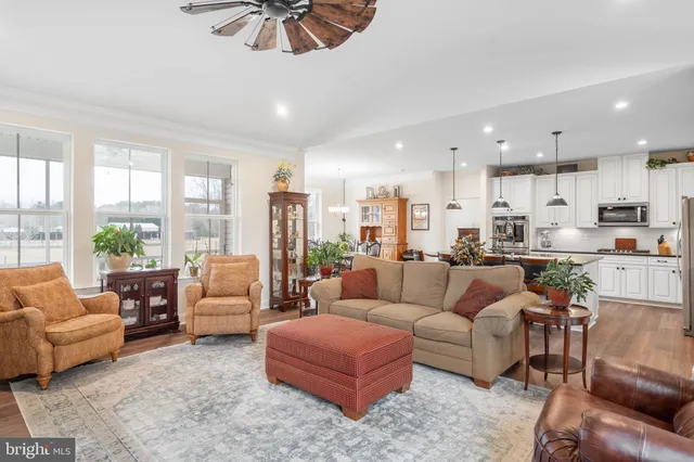 a kitchen with stainless steel appliances kitchen island granite countertop a table chairs and a sink