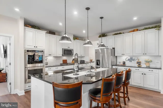 a kitchen with stainless steel appliances granite countertop a sink refrigerator and cabinets