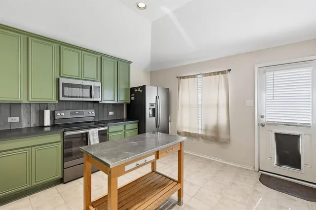 a kitchen with stainless steel appliances granite countertop a stove a refrigerator and a microwave
