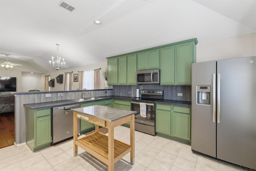 1201 Roping Reins Way Fort Worth, TX 76052 - Photo 14 of 34 a kitchen with stainless steel appliances granite countertop a stove top oven a sink dishwasher a refrigerator and a microwave
