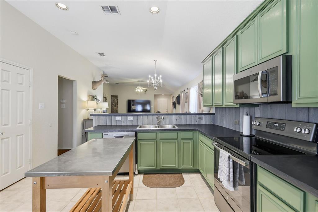 1201 Roping Reins Way Fort Worth, TX 76052 - Photo 15 of 34 a kitchen with stainless steel appliances granite countertop a sink a stove top oven a counter space and cabinets