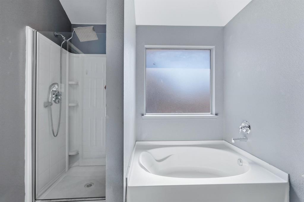 1201 Roping Reins Way Fort Worth, TX 76052 - Photo 22 of 34 a white bath tub sitting next to a shower