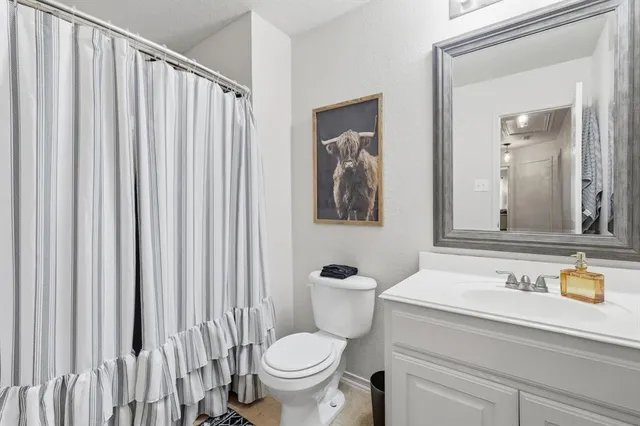 a bathroom with a toilet a sink and a mirror