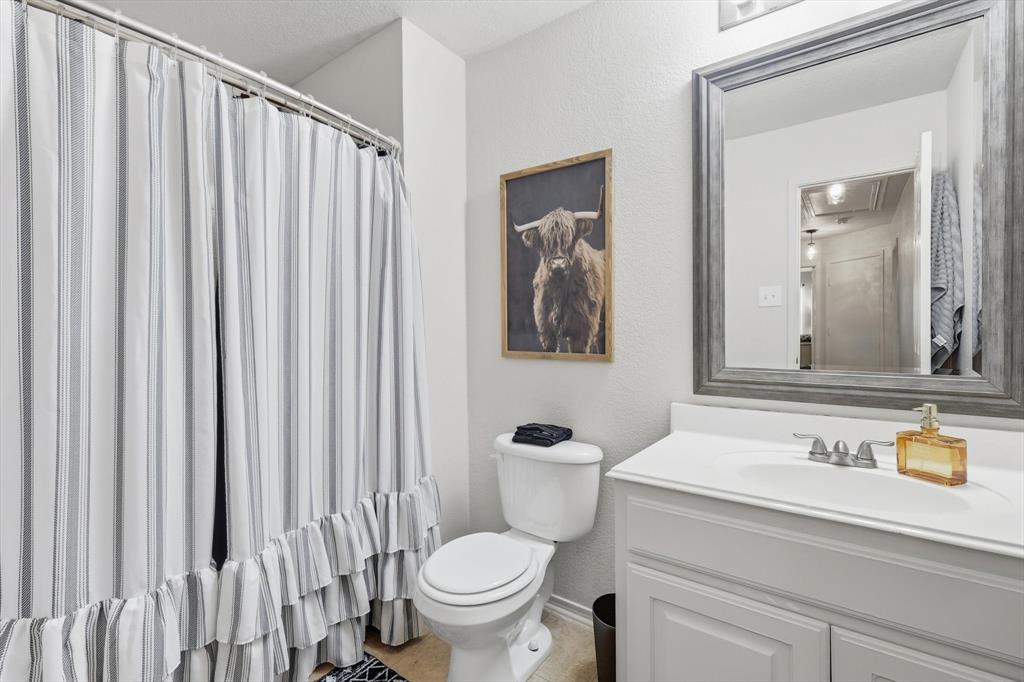 1201 Roping Reins Way Fort Worth, TX 76052 - Photo 26 of 34 a bathroom with a toilet a sink and a mirror