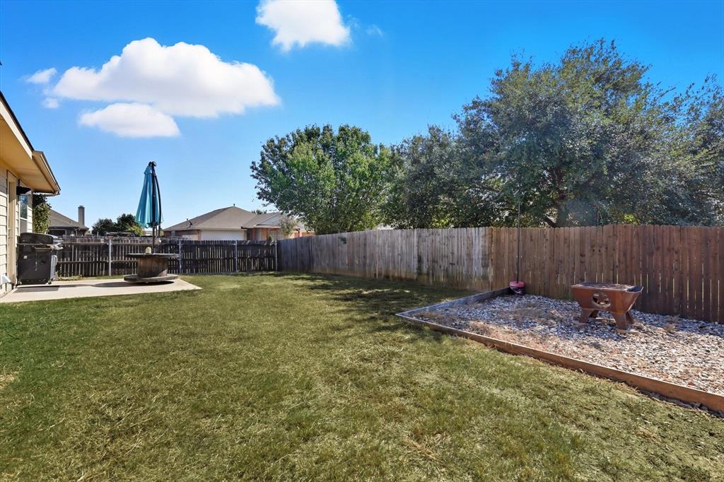 1201 Roping Reins Way Fort Worth, TX 76052 - Photo 31 of 34 a backyard of a house with table and chairs