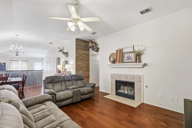 a living room with furniture a fireplace and a ceiling fan