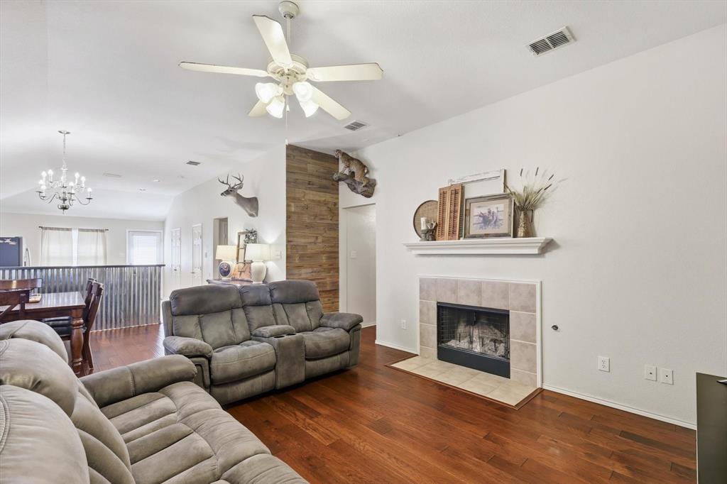 1201 Roping Reins Way Fort Worth, TX 76052 - Photo 5 of 34 a living room with furniture a fireplace and a ceiling fan