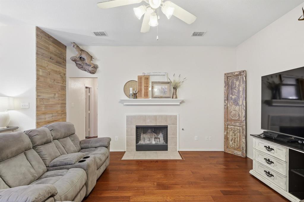 1201 Roping Reins Way Fort Worth, TX 76052 - Photo 6 of 34 a living room with furniture a fireplace and a flat screen tv