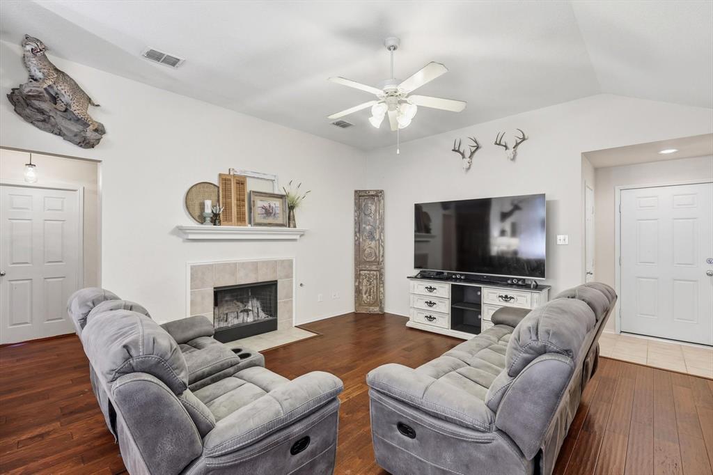 1201 Roping Reins Way Fort Worth, TX 76052 - Photo 7 of 34 a living room with furniture a flat screen tv and a fireplace