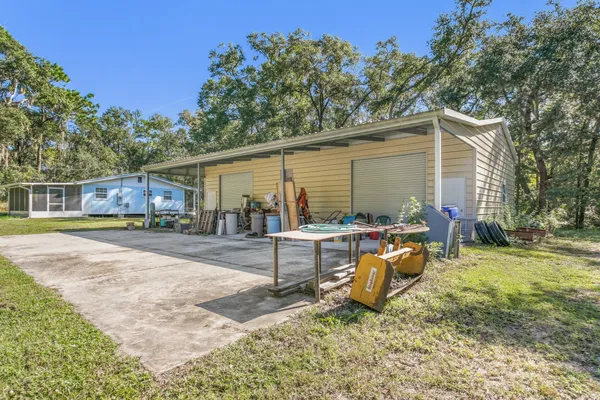 a view of a house with backyard and sitting area