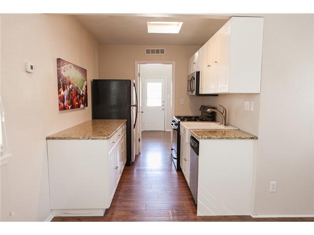 1106 West 22nd Street, Unit 9 Austin, TX 78705 - Photo 6 of 11 a kitchen with a refrigerator and a sink