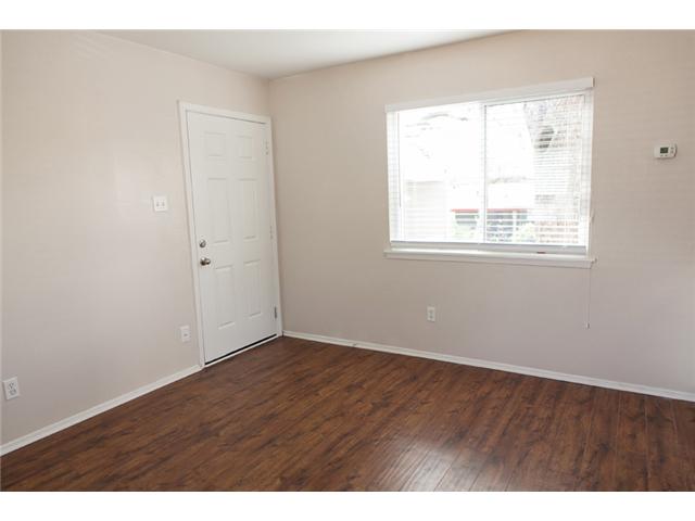 1106 West 22nd Street, Unit 9 Austin, TX 78705 - Photo 7 of 11 an empty room with wooden floor and windows
