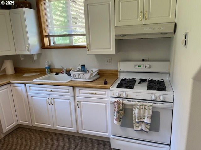 78544 Rat Creek Road Cottage Grove, OR 97424 - Photo 23 of 44 a kitchen with white cabinets and white appliances