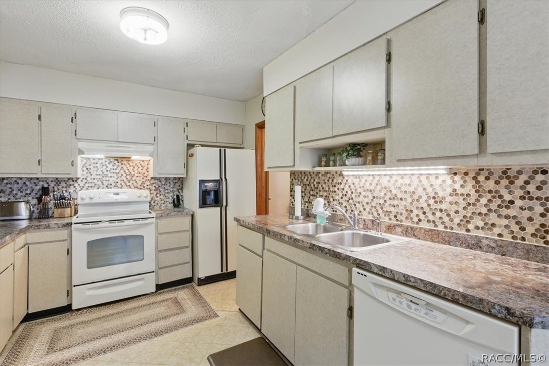 6 62nd Street Yankeetown, FL 34498 - Photo 14 of 55 a kitchen with granite countertop white cabinets and white appliances