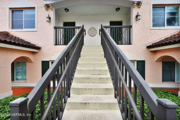 a view of staircase with lots of frames on wall and windows