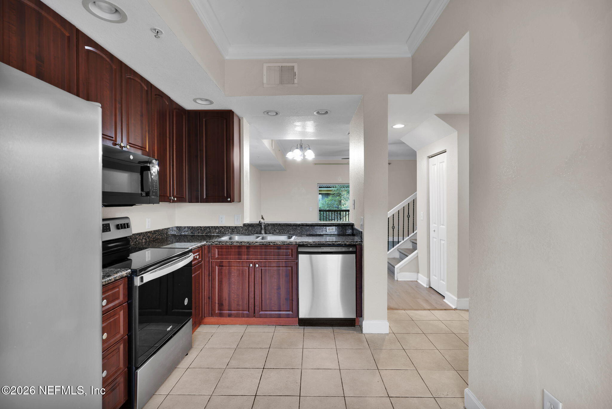 9745 Touchton Road, Unit 526 Jacksonville, FL 32246 - Photo 12 of 34 a kitchen with stainless steel appliances granite countertop a stove a sink and a refrigerator
